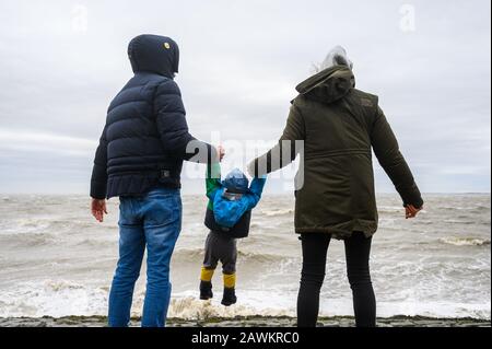 Wilhelmshaven, Allemagne. 9 février 2020. Les parents Bianca et Benni sont avec leur fils Bela sur la plage de la mer du Nord de Wilhelmshaven pendant la tempête 'Stabine'. Crédit: Mohssen Assanimoghaddam/Dpa/Alay Live News Banque D'Images