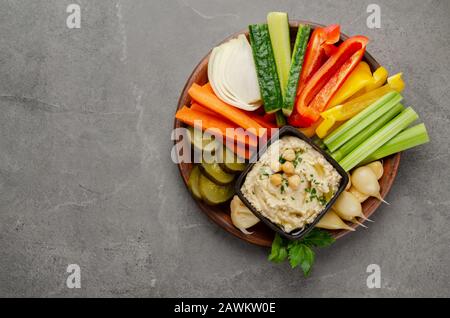 Vue sur la couche plate de la boîte à tremper Hummus végétale surmontée de pois chiches et d'huile d'olive Banque D'Images