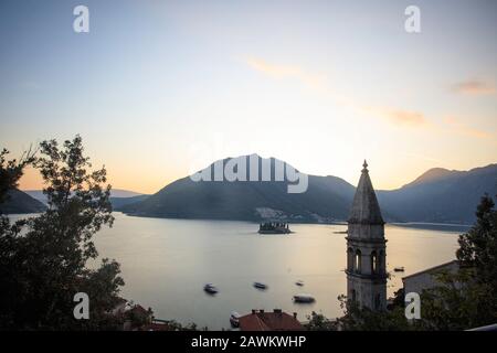 Coucher de soleil sur Perast avec l'église Saint Nicolas sur la droite et les îlots, Sveti Dorde et Notre Dame des rochers juste derrière. Baie De Kotor. Monténégro Banque D'Images