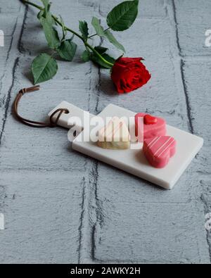 Bonbons en forme de coeur en massepain et une rose pour la Saint-Valentin Banque D'Images