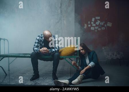 Kidnappeur de manac et menotté à la victime sur le lit Banque D'Images