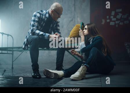 Kidnappeur de manac et menotté à la victime sur le lit Banque D'Images