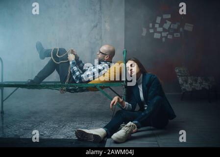 Kidnappeur de manac et menotté au lit Banque D'Images