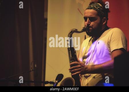 Valletta / Malte - 1 septembre 2019: Un jeune homme avec une barbe jouant le saxophone sur scène lors d'un festival de musique Banque D'Images