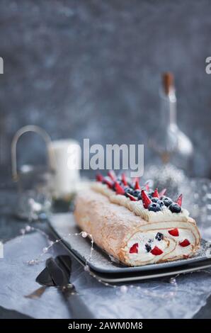 Gâteau au rouleau meringue avec crème et baies fraîches Banque D'Images