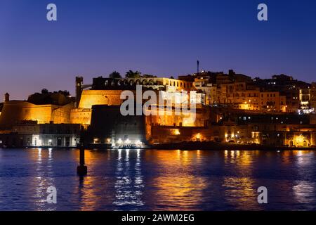 Ville de la Valette à Malte au crépuscule du soir, vue sur la mer avec réflexion dans le Grand Harbour. Banque D'Images