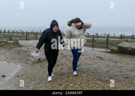 Portland Bill, Dorset, Royaume-Uni. 9 février 2020. Météo britannique. Les visiteurs de Portland Bill à Dorset ont du mal à se tenir dans les vents de la force de Gale de Storm Ciara. Crédit Photo : Graham Hunt/Alay Live News Banque D'Images