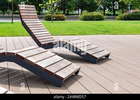 Concept moderne d'architecture de ville - des chaises longues vides en bois dans le parc public Banque D'Images