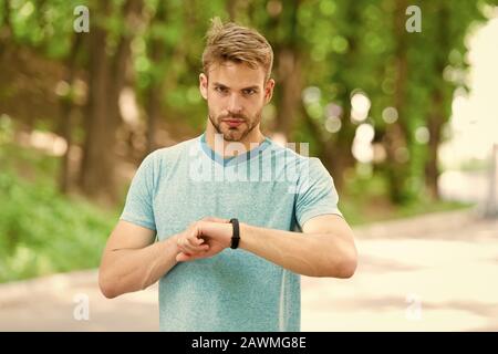 Formation de sportif avec smart watch. Mettre en place de suivi de remise en forme. Coach de remise en forme. Les paramètres utiles. Bracelet gadget. Vérifier l'athlète tracker remise en forme nature background. Look sportif podomètre gadget. Banque D'Images