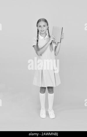 Journal intime pour les filles concept. happy little girl en rétro vintage kid fashion. uniforme. retour à l'école. girl cahier hold ou notepad. livre encyclopédie pour les enfants. petite fille l'amour de la littérature. La vieille école. Banque D'Images