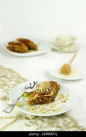 Concept de sucré turc. Triangles baklava, dessert turc traditionnel sucré avec pâte phyllo, noix et miel. Fond blanc. Banque D'Images