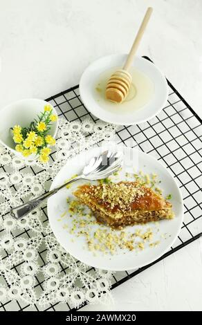 Concept de sucré turc. Triangles baklava, dessert turc traditionnel sucré avec pâte phyllo, noix et miel. Fond blanc. Banque D'Images