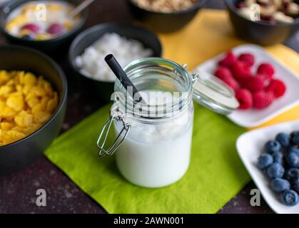 délicieux lait de coco avec flocons de noix de coco dans le pot de conservation avec la paille Banque D'Images