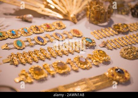 Bijoux dorés de luxe - bracelets dorés brillants et ventilateurs à main. Variété de beaux bijoux anciens de la famille royale à l'exposition à la boutique. Cadeau Cher Banque D'Images