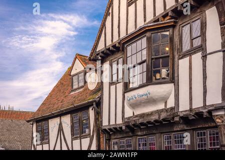 L'étage supérieur d'un bâtiment médiéval à colombages à York, maintenant un restaurant. Un panneau est suspendu d'un coin et un ciel avec des nuages est au-dessus. Banque D'Images