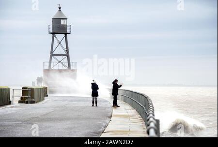 Wilhelmshaven, Allemagne. 9 février 2020. Passants prendre des photos des vagues pendant la tempête 'Stabine' sur une jetée au feu croisé dans le nord-est de la ville. Crédit: Hauke-Christian Dittrich/Dpa/Alay Live News Banque D'Images