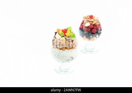 Deux verres de cognac avec fruits secs. Fruits secs sur fond blanc. Banque D'Images