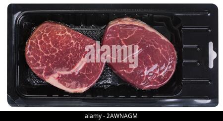 Deux steaks en conditionnement sous vide isolés sur fond blanc, vue de dessus Banque D'Images