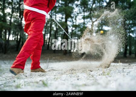 Le Père Noël jouant au golf pendant la journée Banque D'Images