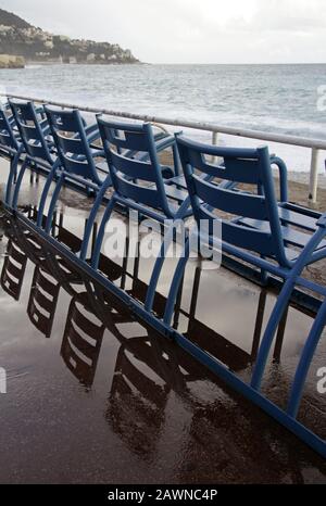 Photo verticale des chaises bleues se reflétant sur le sol à la plage Banque D'Images