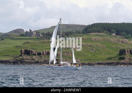 Yacht à voile en passant par le château de Glengorm, l'île de Mull, Inner Hebrides, Écosse Banque D'Images