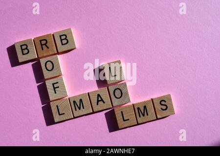 Internet slang, acronymes en lettres en bois en forme de mot croisé sur un fond rose avec espace de copie Banque D'Images