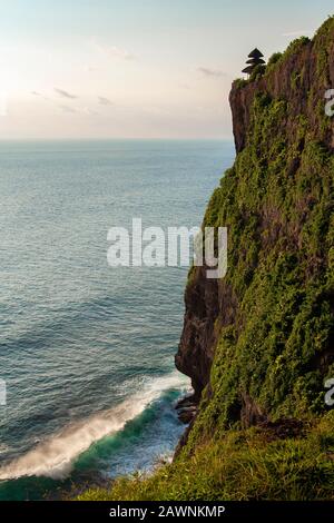 Vue imprenable sur un temple, une falaise abrupte et l'océan à Uluwatu à Bali, Indonésie. Banque D'Images