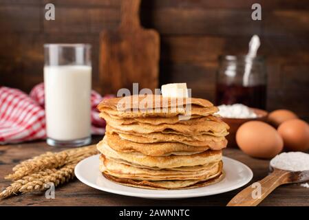 Blini, blintzes, crêpes russes empilées sur plaque sur fond de composition rustique. Concept de vacances nationales traditionnelles Maslenitsa Banque D'Images