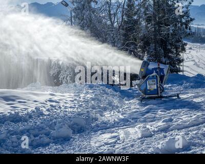 Machine de fabrication de neige, appelée canon à neige ou canon à neige en action. Montagnes polonaises Tatra et en arrière-plan Banque D'Images