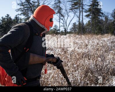 Mapleville Rhode Island, 20 décembre 2019: Un chasseur d'oiseaux Portant UN masque et Reloading UN fusil de chasse Banque D'Images