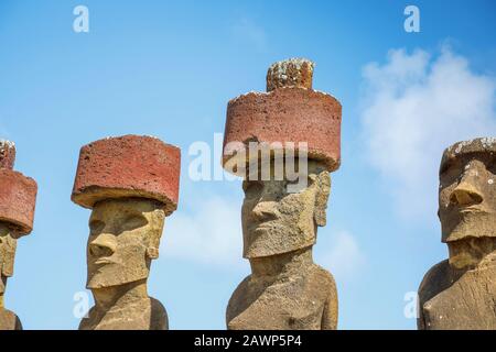 Vue sur les têtes de moai restauré avec des arnaques rouges se tenant sur Ahu Nao-Nao, plage d'Anakena sur la côte nord de l'île de Pâques (Rapa Nui) Banque D'Images