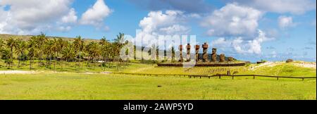 Statues Moai restaurées avec des nœuds rouges de la storia debout sur Ahu Nao-Nao sur la plage d'Anakena bordée de palmiers sur la côte nord de l'île de Pâques (Rapa Nui) Banque D'Images