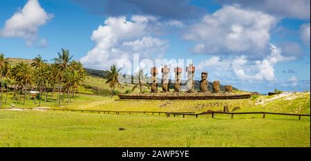 Statues Moai restaurées avec des nœuds rouges de la storia debout sur Ahu Nao-Nao sur la plage d'Anakena bordée de palmiers sur la côte nord de l'île de Pâques (Rapa Nui) Banque D'Images