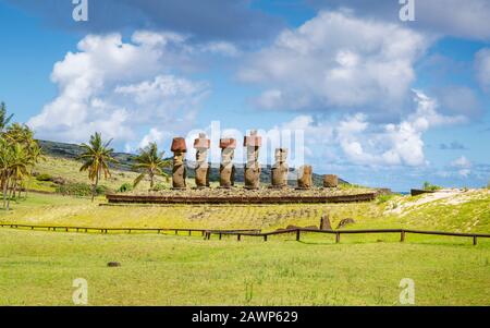 Statues Moai restaurées avec des nœuds rouges de la storia debout sur Ahu Nao-Nao sur la plage d'Anakena bordée de palmiers sur la côte nord de l'île de Pâques (Rapa Nui) Banque D'Images