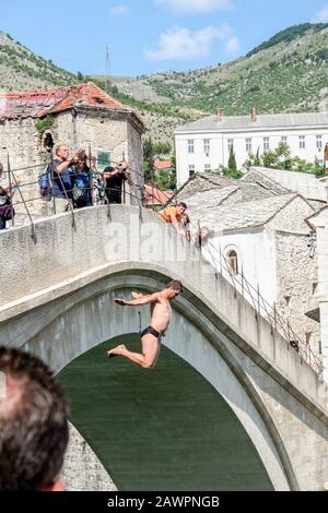 Mostar, BOSNIE-HERZÉGOVINE - 3 JUIN 2009: Homme en maillot de bain sautant du vieux pont de Mostar dans la rivière Neretva pendant un après-midi ensoleillé. C'est moi Banque D'Images