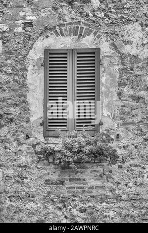 Fenêtre panoramique dans l'architecture médiévale de San Gimignano, ville emblématique de la province de Sienne, et l'un des endroits les plus visités de Toscane, Italie Banque D'Images