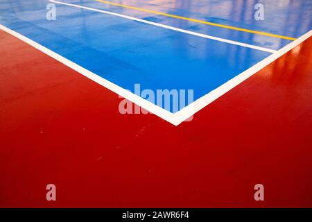 Motif graphique rouge et bleu coloré sur le terrain de sport avec lignes de contact d'angle, vue en perspective. Banque D'Images