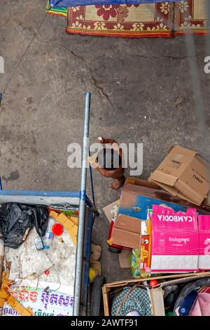 Un jeune cambodgien pauvre et sans abri de 3 ans, qui travaille comme un piégeur, se penche sur un chariot de collecte de déchets à Kampong Cham, au Cambodge. Banque D'Images