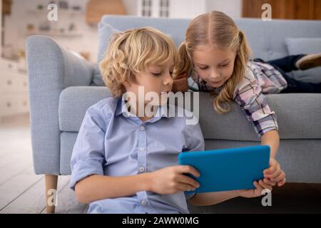 Garçon et fille regardant quelque chose sur tablette Banque D'Images