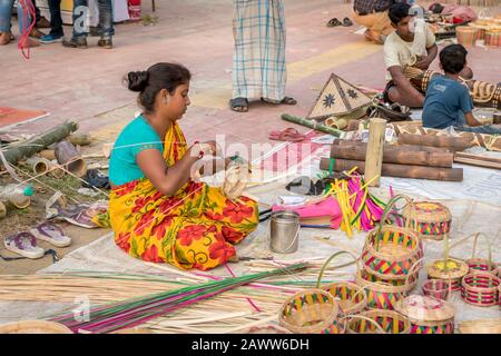 Une femme indienne non identifiée préparant des objets en bambou sculptant des bâtonnets de bambou à vendre à Kolkata dans le salon de l'artisanat. C'est l'indist rural Banque D'Images