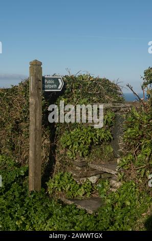 « sentier public » Sign Post by a Stone Stile in the Cornish Village of Trevalga on the North Coast of Cornwall, Angleterre, Royaume-Uni Banque D'Images