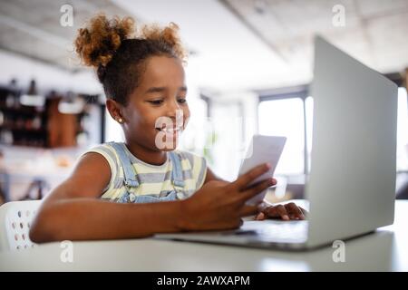 Jeu, étude, concept amusant. Des enfants heureux de passer du temps avec un ordinateur portable et la technologie moderne. Banque D'Images