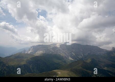 Cloud streaming au-dessus des falaises du groupe Rosengarten vue sur les pentes du Plattkofel Val Gardena Dolomites Tyrol du Sud Italie Banque D'Images