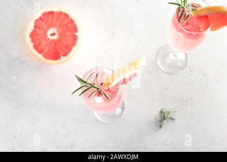 Cocktail Mimosa avec champagne, pamplemousse et romarin en flûte, vue de dessus, espace de copie. Mocktail, boisson gazeuse aux agrumes Mimosa. Banque D'Images