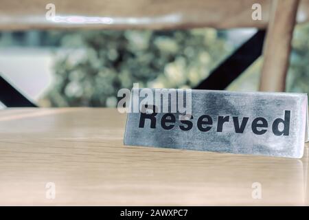 Panneau de table réservée en acier inoxydable sur la table en bois du restaurant pour qui a réservé le siège, personne d'importance avec service prioritaire Banque D'Images