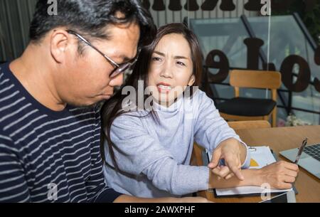 Une femme d'affaires intelligente asiatique discute sérieusement d'un argument sur le travail avec un homme d'affaires portant un costume moderne informel au bureau de l'espace de travail Banque D'Images