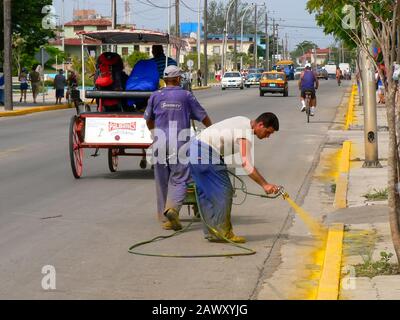 Les travailleurs qui pulvérisent de la peinture sur une route à Varadero, Cuba Banque D'Images