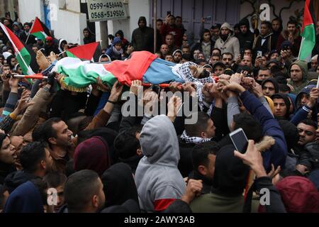 8 Février 2020: Cisjordanie, Palestine. 09 Février 2010. Les bourneurs portent le corps de Badr Nafla palestinien dans le village de Qaffin dans le district de Tulkarem en Cisjordanie. Bader Nidal Nafla Harha, 19 ans, a été prononcé mort peu après avoir été abattu et grièvement blessé par les troupes israéliennes lors de manifestations près du village de Qaffin, dans le nord de la Cisjordanie, vendredi soir. Des protestations ont éclaté contre le président américain Trump « œDeal du Centuryâ€ » et l'annexion des colonies israéliennes en Cisjordanie. Badar Nafla est la quatrième jeunesse palestinienne à être tué ces derniers jours depuis Trumpâ€™s Banque D'Images