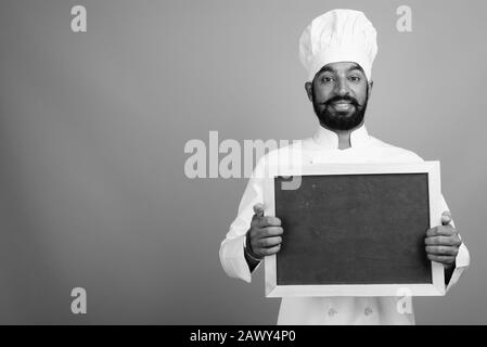 Jeune homme indien barbu comme chef tenant le tableau noir Banque D'Images