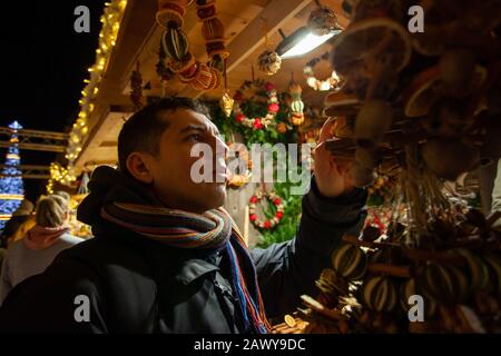 Homme achetant un cadeau d'arôme sur le marché de noël Banque D'Images